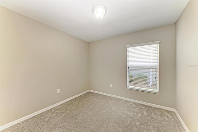 carpeted spare room featuring baseboards