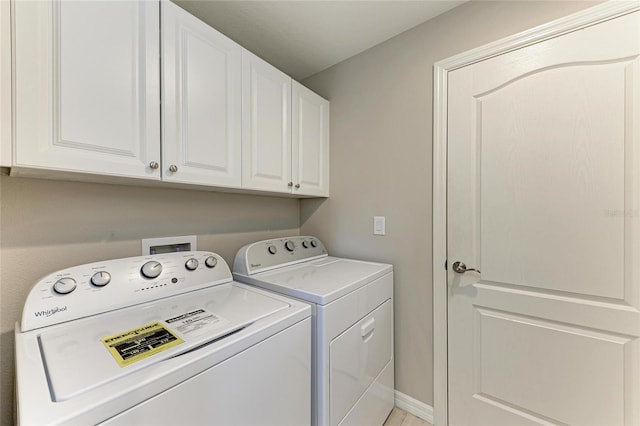 clothes washing area featuring washing machine and clothes dryer and cabinet space