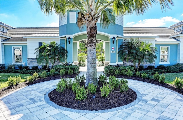 view of front facade with curved driveway and stucco siding