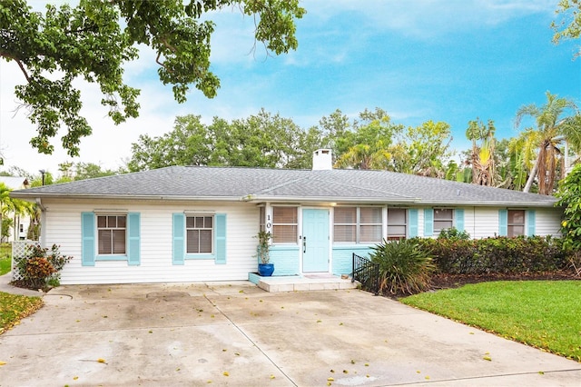 104 Shoreland Dr, Osprey, FL 34229 - single story home with a chimney, a front lawn, and concrete driveway