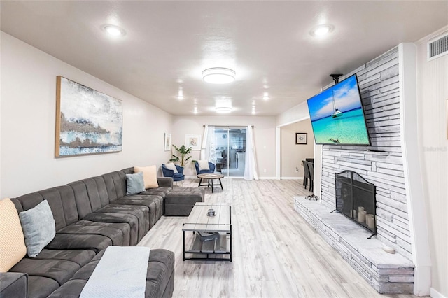 104 Shoreland Dr, Osprey, FL 34229 - living area featuring wood finished floors, visible vents, baseboards, and a stone fireplace