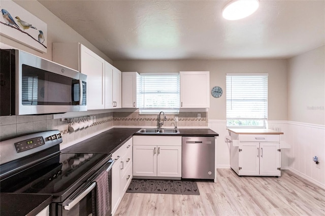 104 Shoreland Dr, Osprey, FL 34229 - kitchen with appliances with stainless steel finishes, a healthy amount of sunlight, a sink, and light wood-style flooring