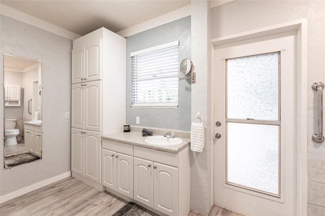 104 Shoreland Dr, Osprey, FL 34229 - full bath with toilet, vanity, wood finished floors, and baseboards