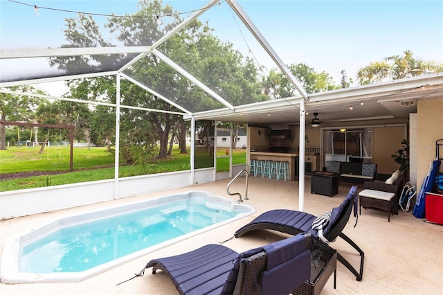 104 Shoreland Dr, Osprey, FL 34229 - outdoor pool featuring a lawn, outdoor lounge area, glass enclosure, and a patio
