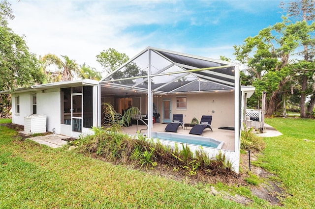 104 Shoreland Dr, Osprey, FL 34229 - rear view of house featuring glass enclosure, an outdoor pool, a yard, a patio, and stucco siding
