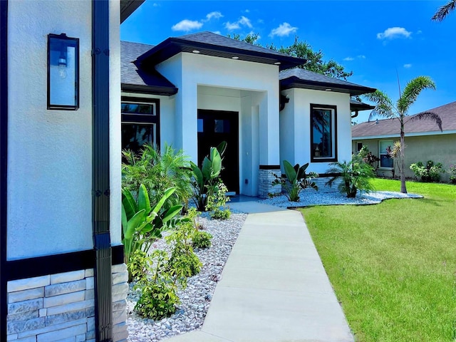 22 Medalist Cir, Rotonda West, FL 33947 - entrance to property with a lawn, stucco siding, and roof with shingles
