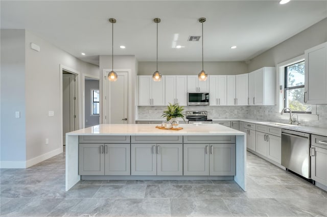 22 Medalist Cir, Rotonda West, FL 33947 - kitchen featuring tasteful backsplash, appliances with stainless steel finishes, a sink, gray cabinetry, and visible vents