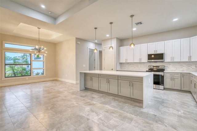 22 Medalist Cir, Rotonda West, FL 33947 - kitchen with decorative backsplash, appliances with stainless steel finishes, visible vents, a center island, and gray cabinets