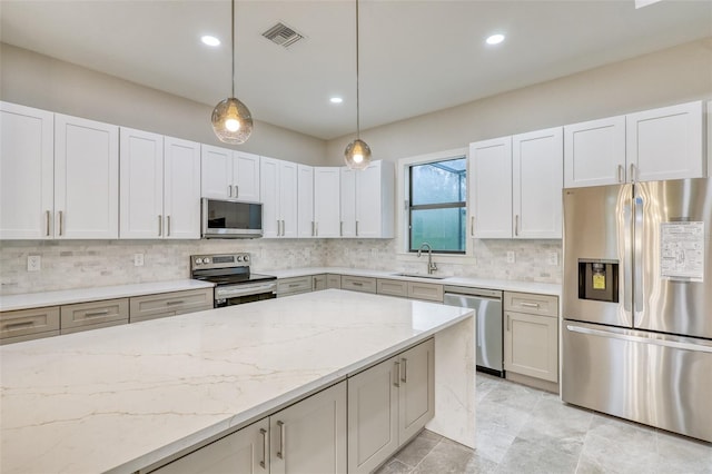 22 Medalist Cir, Rotonda West, FL 33947 - kitchen featuring decorative backsplash, a sink, visible vents, stainless steel appliances, and light stone countertops