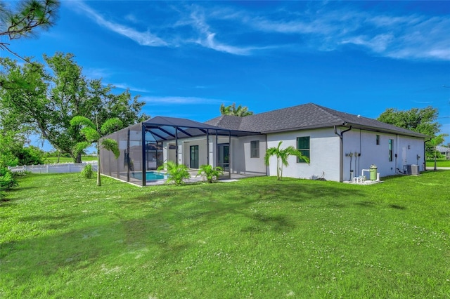 22 Medalist Cir, Rotonda West, FL 33947 - back of house with stucco siding, a yard, glass enclosure, central AC unit, and a patio area