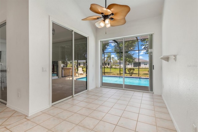 unfurnished room featuring baseboards, a ceiling fan, and light tile patterned floors