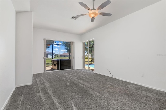 carpeted empty room with baseboards, a ceiling fan, and visible vents