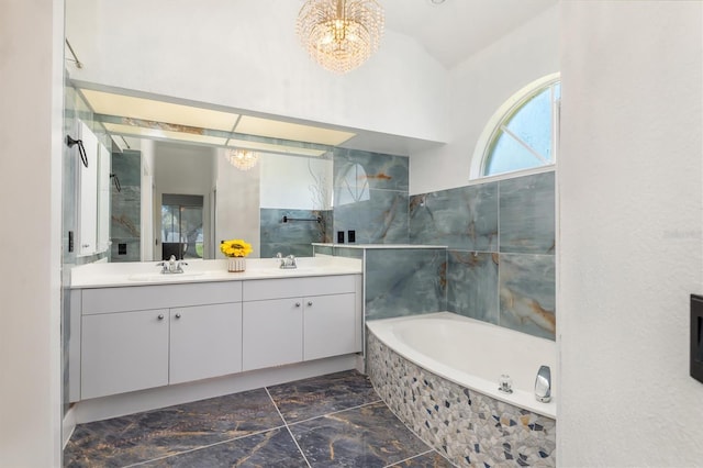 bathroom featuring a bath, a notable chandelier, a sink, and double vanity