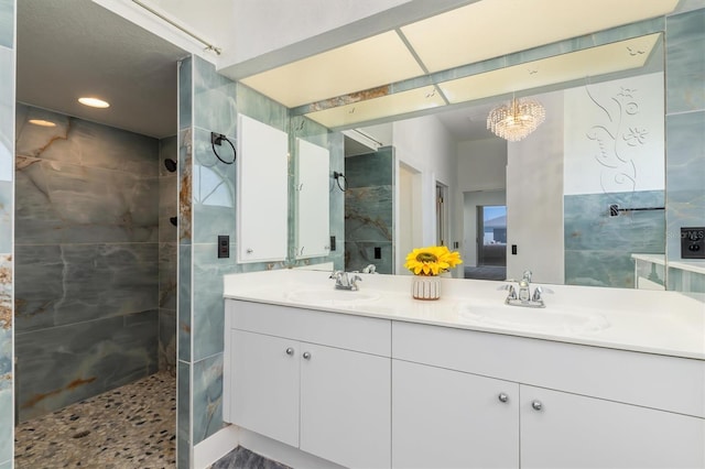 full bathroom with double vanity, walk in shower, and a sink