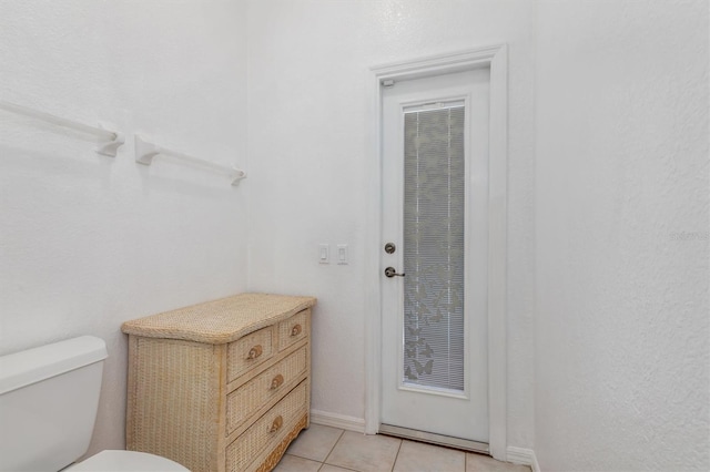 bathroom with tile patterned flooring, toilet, and baseboards