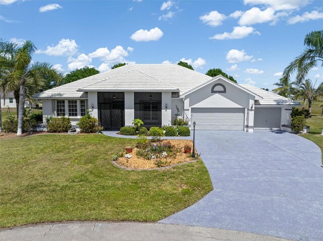 ranch-style house featuring a tiled roof, concrete driveway, a garage, a front yard, and stucco siding