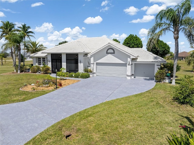 ranch-style home featuring a tiled roof, a front lawn, stucco siding, an attached garage, and driveway