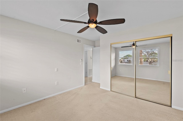 unfurnished bedroom with baseboards, visible vents, a ceiling fan, and carpet floors