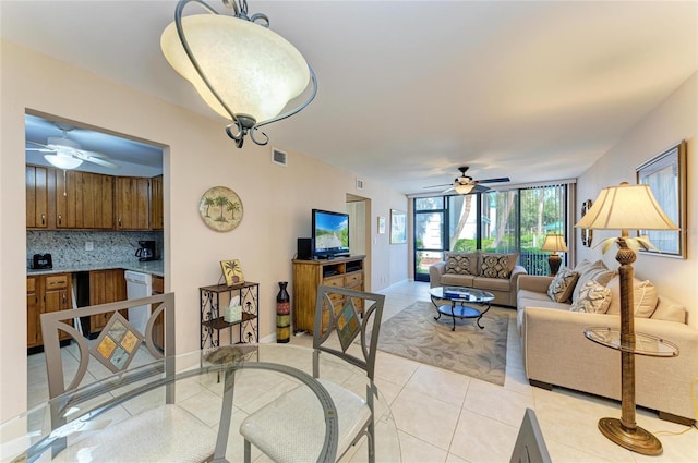 living area featuring visible vents, baseboards, ceiling fan, and light tile patterned floors