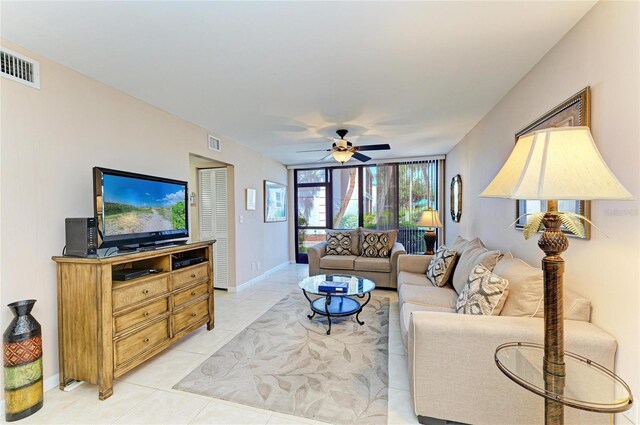 living room featuring visible vents, a ceiling fan, baseboards, and light tile patterned floors
