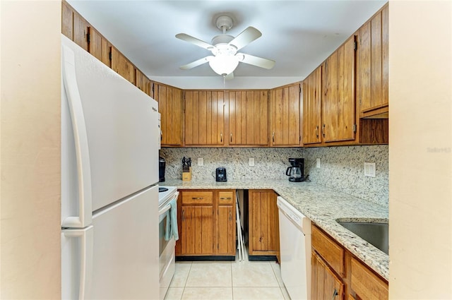 kitchen featuring a sink, backsplash, white appliances, brown cabinetry, and light tile patterned floors
