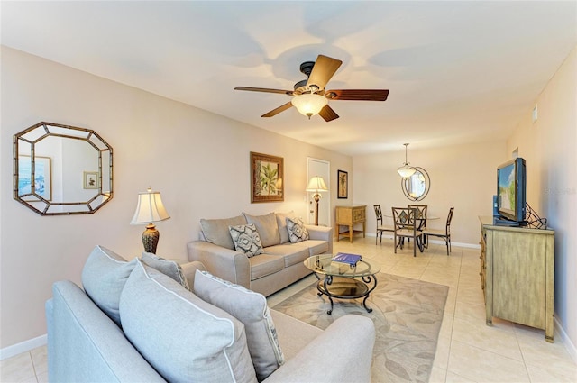 living room with light tile patterned flooring, baseboards, and ceiling fan