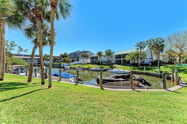 view of dock with a yard, a water view, and a residential view
