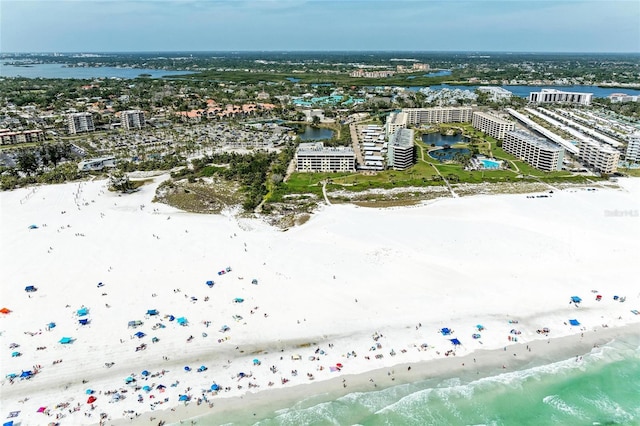 drone / aerial view featuring a beach view, a city view, and a water view