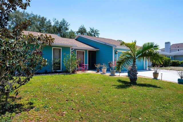 4219 Berkshire Dr, Sarasota, FL 34241 - view of front facade featuring a garage, driveway, a front lawn, and roof with shingles
