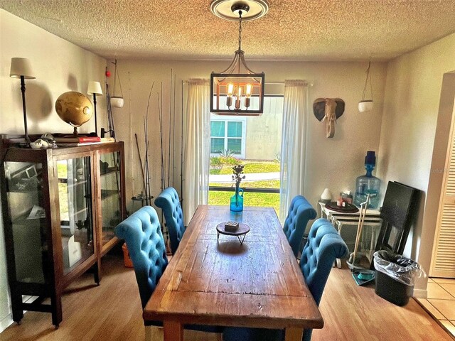 4219 Berkshire Dr, Sarasota, FL 34241 - dining area featuring a textured ceiling, a notable chandelier, and wood finished floors