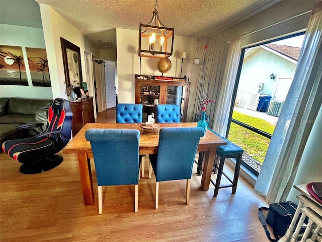 4219 Berkshire Dr, Sarasota, FL 34241 - dining space featuring a textured ceiling, a chandelier, and wood finished floors