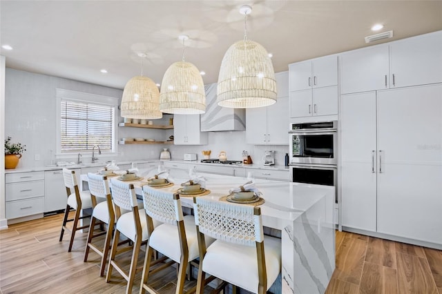 723 S Blvd Of The Presidents, Sarasota, FL 34236 - kitchen with double oven, light countertops, dishwasher, visible vents, and a kitchen bar