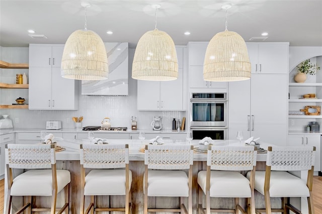 723 S Blvd Of The Presidents, Sarasota, FL 34236 - kitchen with open shelves, stainless steel double oven, gas cooktop, and backsplash