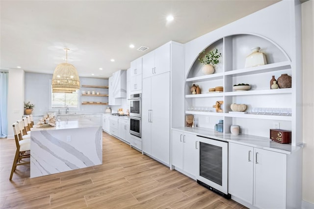 723 S Blvd Of The Presidents, Sarasota, FL 34236 - kitchen featuring wine cooler, visible vents, white cabinetry, stainless steel double oven, and open shelves
