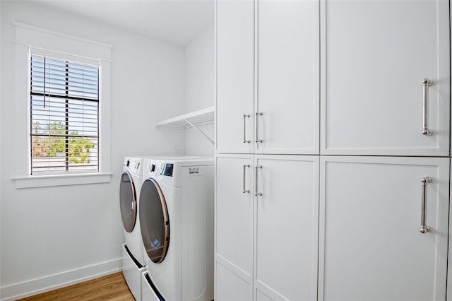 723 S Blvd Of The Presidents, Sarasota, FL 34236 - laundry area with baseboards, cabinet space, light wood-style flooring, and independent washer and dryer