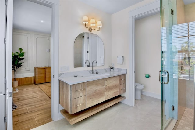 723 S Blvd Of The Presidents, Sarasota, FL 34236 - bathroom with wood finished floors, toilet, vanity, baseboards, and a stall shower