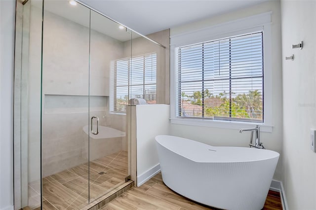 723 S Blvd Of The Presidents, Sarasota, FL 34236 - bathroom with a freestanding bath, baseboards, wood finished floors, and a stall shower