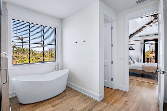 723 S Blvd Of The Presidents, Sarasota, FL 34236 - ensuite bathroom with a freestanding bath, plenty of natural light, baseboards, and wood finished floors