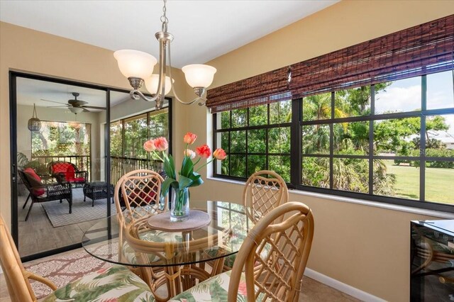 7639 Fairway Woods Dr Unit 605, Sarasota, FL 34238 - dining room featuring baseboards, a wealth of natural light, and ceiling fan with notable chandelier