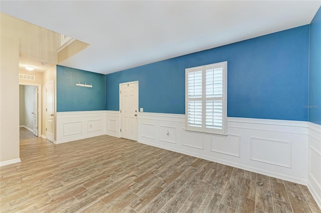 2084 La Palma Ave, Port Charlotte, FL 33953 - spare room with wood finished floors, a wainscoted wall, and a decorative wall