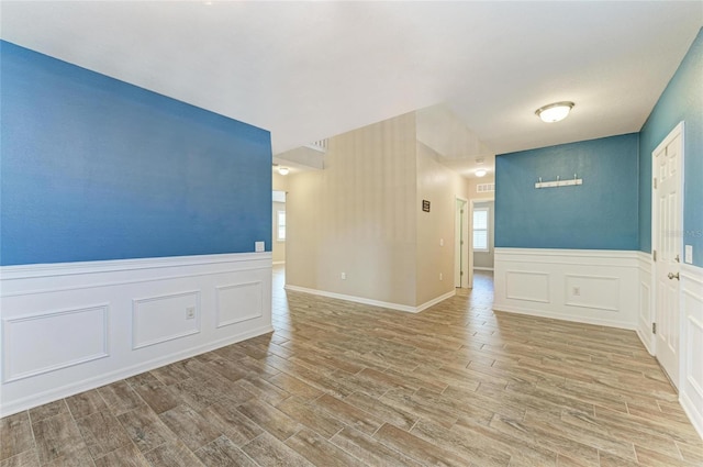 2084 La Palma Ave, Port Charlotte, FL 33953 - empty room with wood finished floors, a decorative wall, and wainscoting