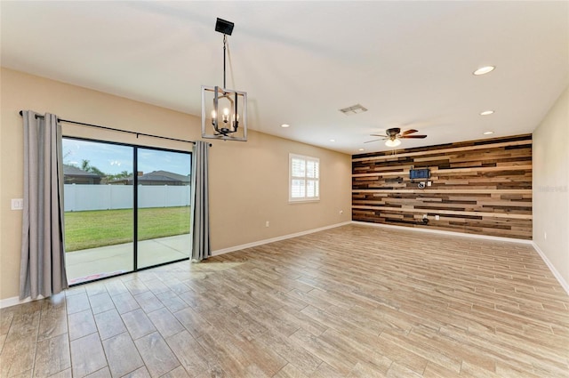 2084 La Palma Ave, Port Charlotte, FL 33953 - unfurnished room with wood walls, baseboards, light wood-type flooring, ceiling fan, and a chandelier