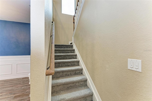 2084 La Palma Ave, Port Charlotte, FL 33953 - stairway featuring wood finished floors, a textured wall, and wainscoting