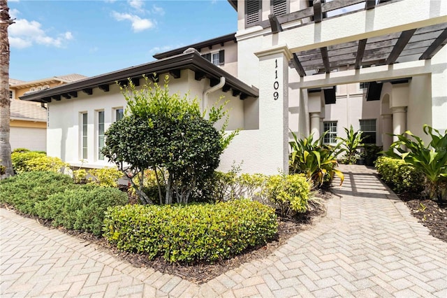 view of home's exterior featuring stucco siding and a pergola