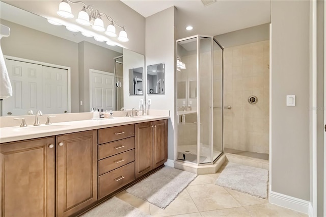 bathroom featuring a sink, tile patterned floors, a shower stall, and double vanity