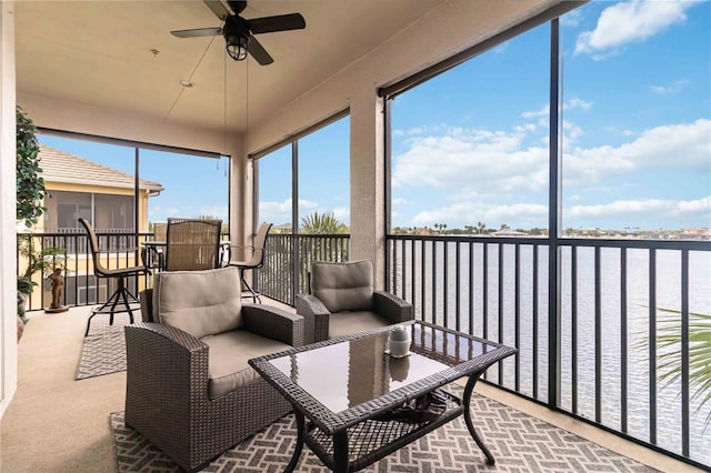sunroom / solarium featuring a ceiling fan and a water view