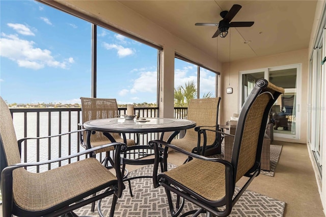 sunroom / solarium with carpet floors, a ceiling fan, and outdoor dining space