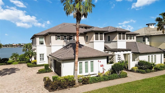 view of front of house with an attached garage, driveway, a residential view, and stucco siding