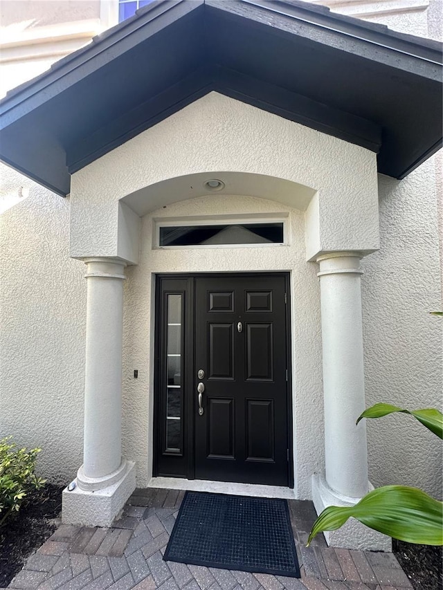 property entrance with stucco siding