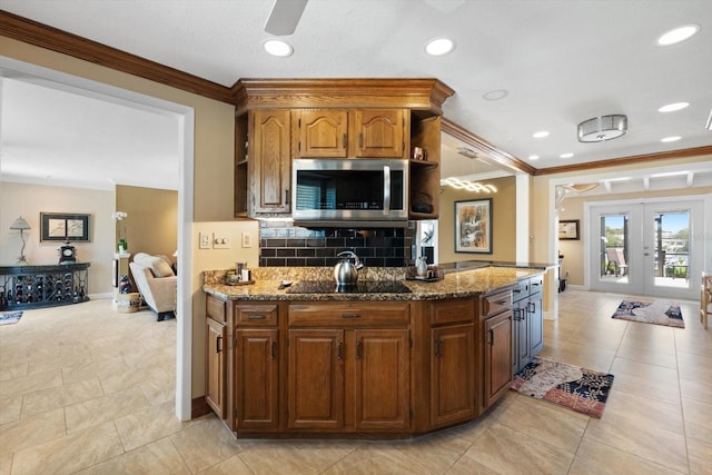 10432 Sandpiper Rd W, Bradenton, FL 34209 - kitchen with stainless steel microwave, tasteful backsplash, black electric stovetop, ornamental molding, and french doors